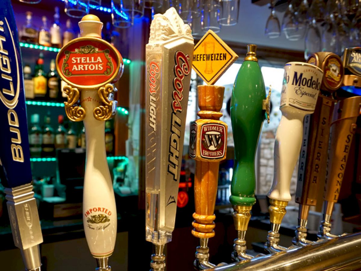 Beer taps for various brands, including Bud Light, Stella Artois, Coors Light, and Modelo, in a bar setting.